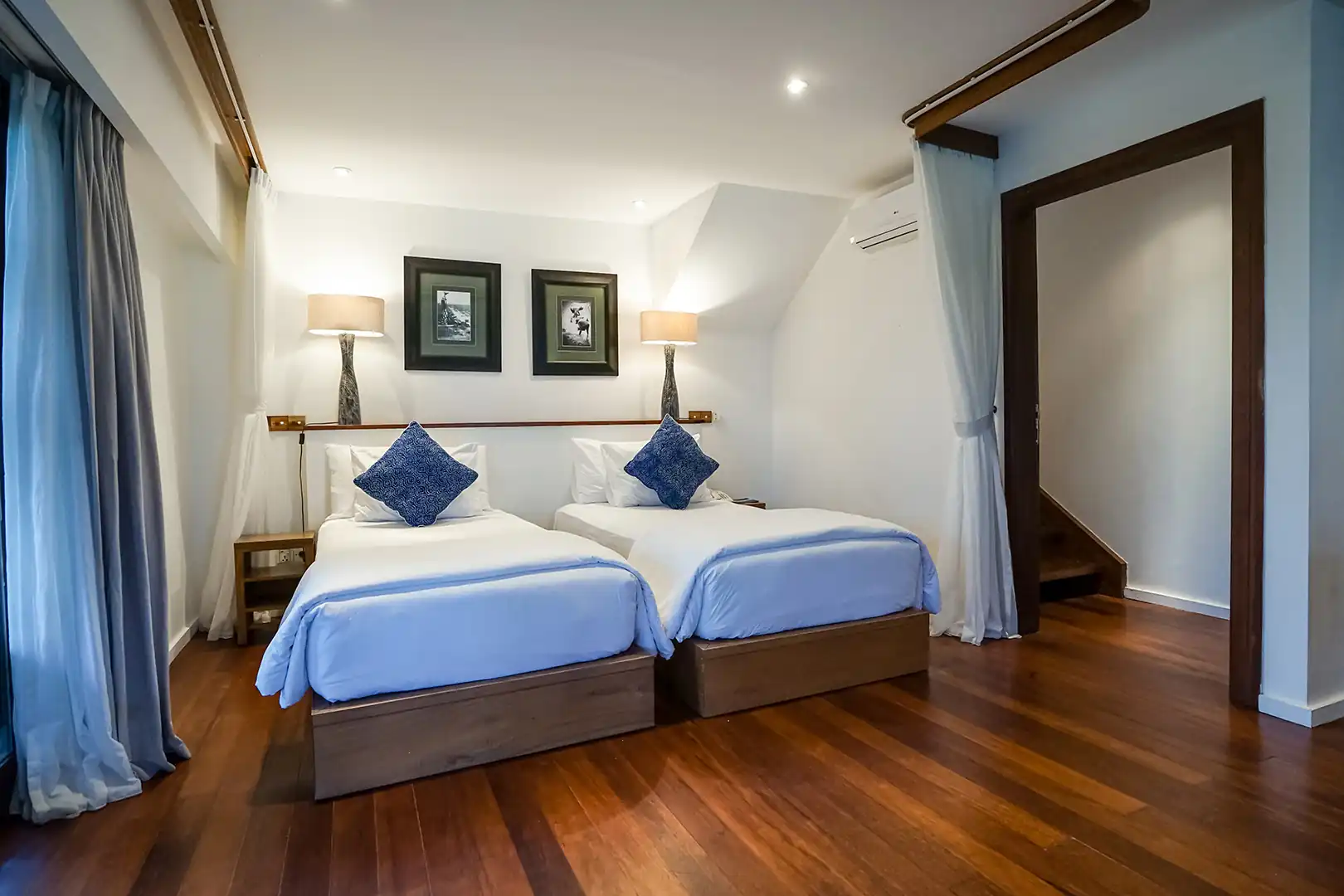 Second-floor bedroom in 2-bedroom ocean view family villa with beautiful bed and desk.