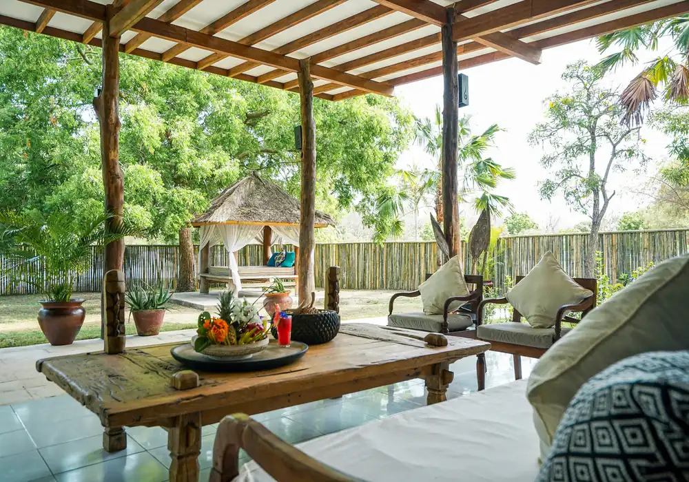 Exterior of the 2 Bedroom Family Villa, showing the large covered terrace and wooden swing, surrounded by a private garden hover