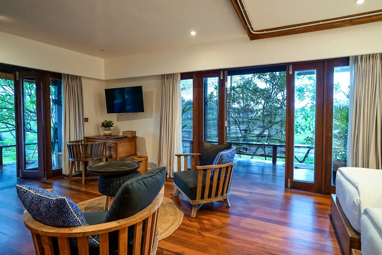 Master bedroom interior of the 2 Bedroom Ocean View Family Villa, showing the unique woven-mat sloping ceiling and a large wicker basket next to the bed hover