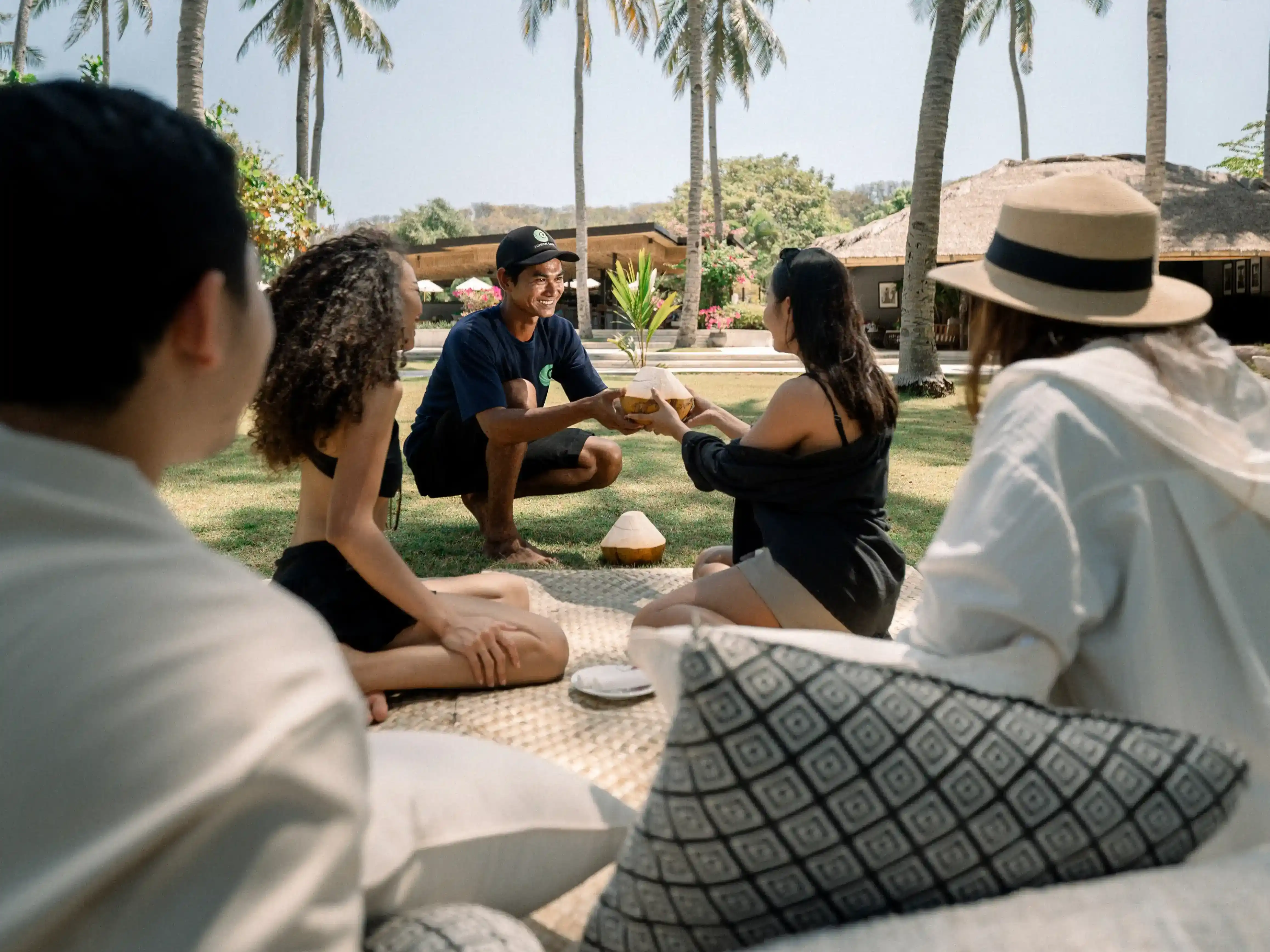 Skilled gardeners climbing palm trees to handpick fresh young coconuts at Pondok Santi Estate hover