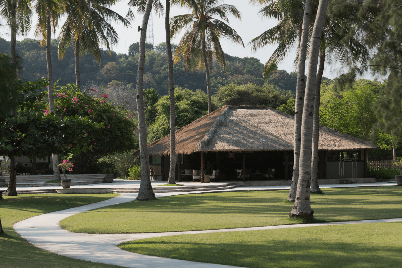 Serene reception house nestled among lush trees, with manicured lawns and coconut palms, Pondok Santi Estate, Gili Trawangan.