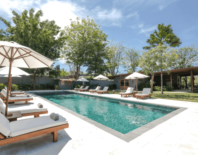 Shared swimming pool at Pondok Santi Estate with inviting lounge chairs, perfect for soaking up the sun.