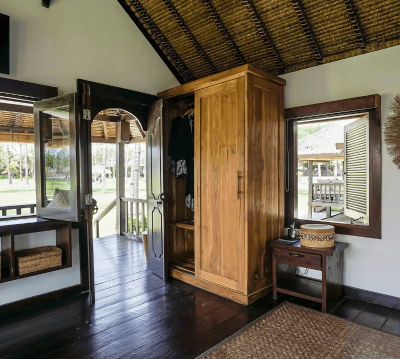 Inside Beachside Bungalow at Pondok Santi Estate, Gili Trawangan, with closet, open door, and windows offering views over the estate.