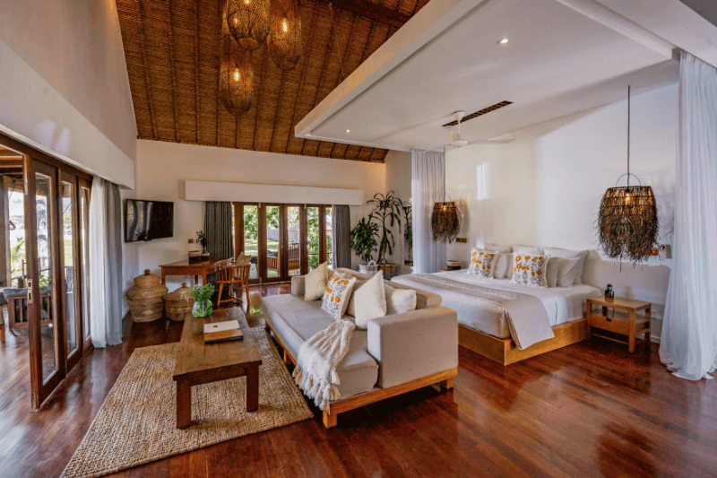 Interior of Ocean View Villa at Pondok Santi Estate, Gili Trawangan, showcasing a beautiful bed, sofas, furniture, and elegant decoration.