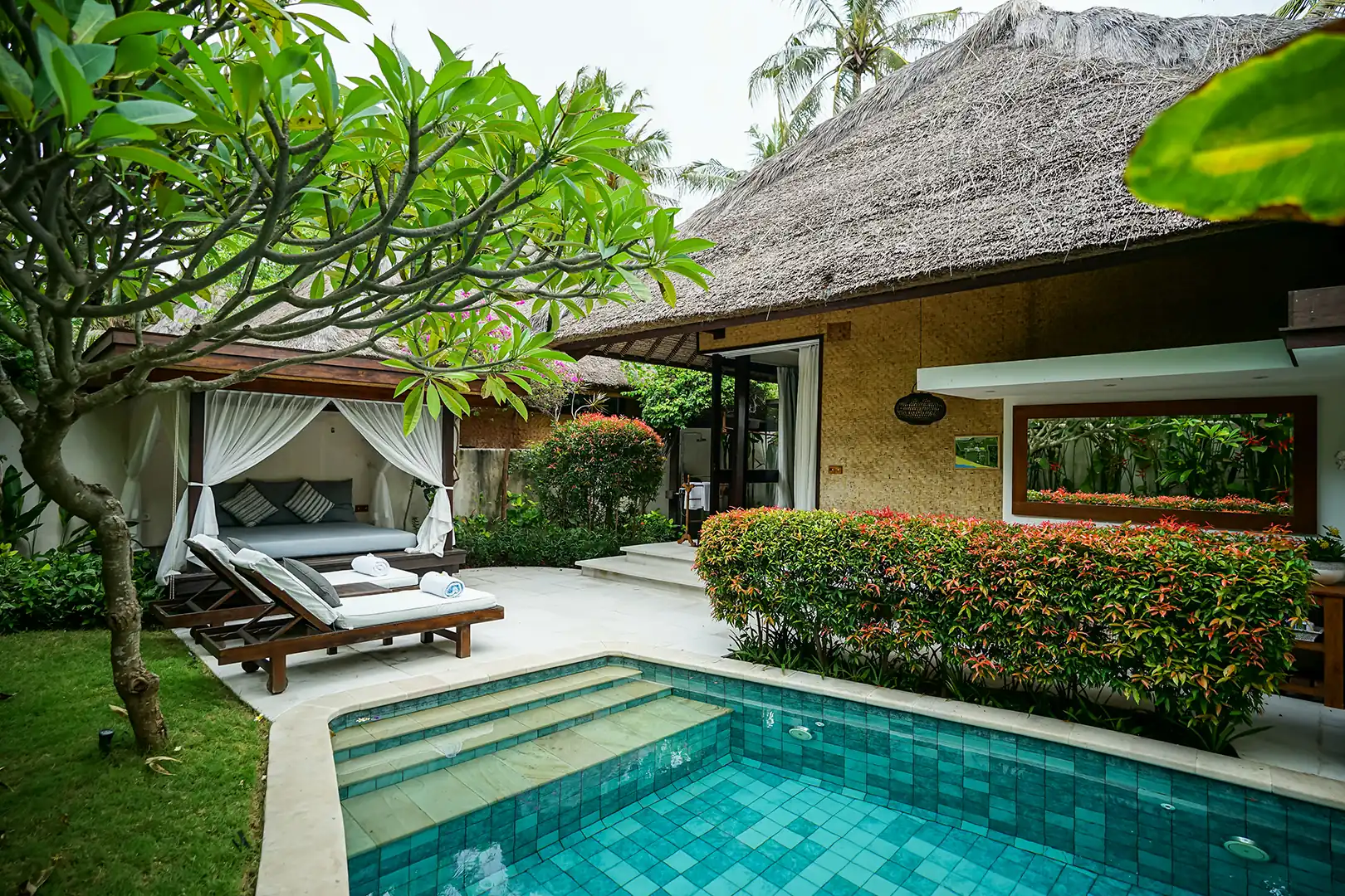 Covered wooden terrace of the Ocean Private Pool Villa, with a small dining or seating area and sliding glass doors leading into the bungalow hover
