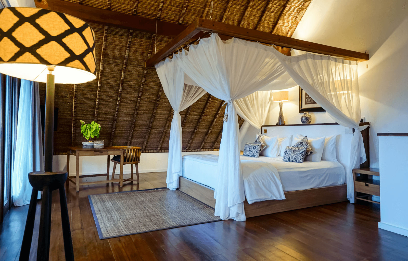 Upstairs bedroom in the two-bedroom ocean view family villa at Pondok Santi Estate, featuring a cozy bed and elegant desk.