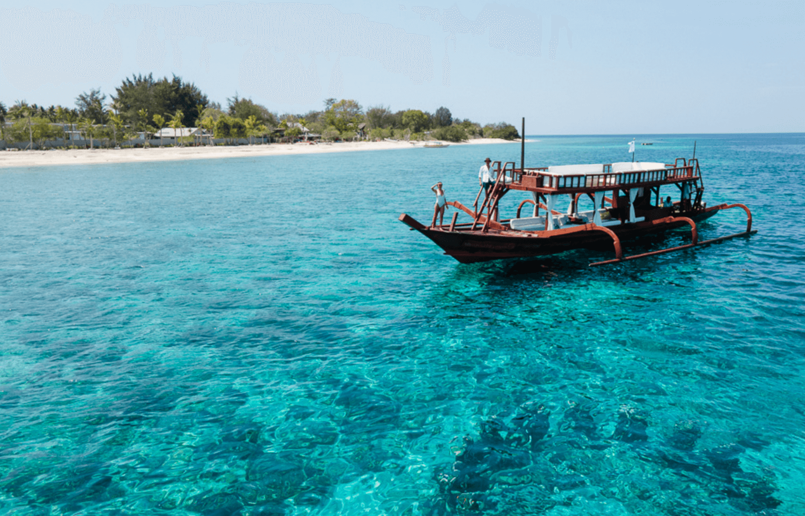 Luxury boat Princess Margaux anchored off Gili Trawangan with crystal-clear waters and island backdrop.