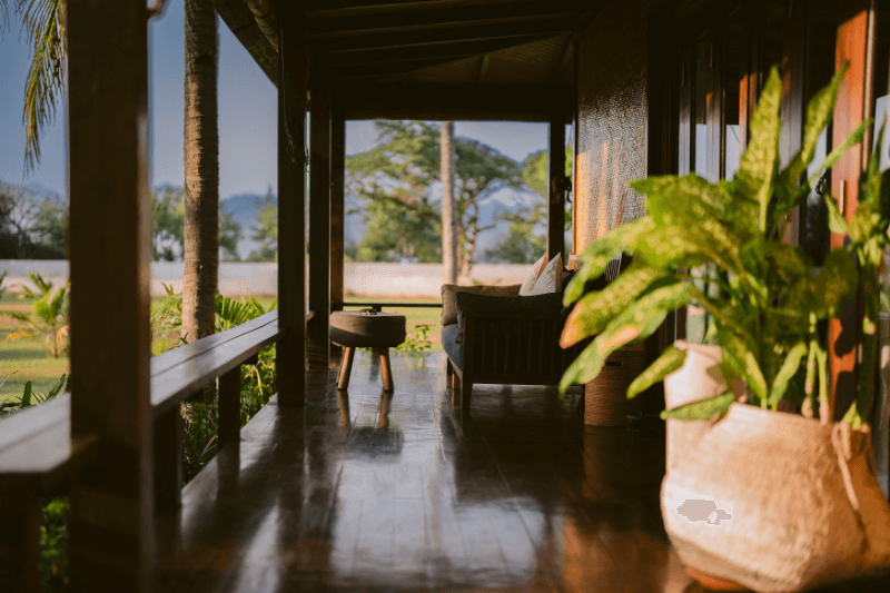 Terrace of Ocean View Villa at Pondok Santi Estate, Gili Trawangan, with a cozy sofa bathed in morning light, ocean in the background.